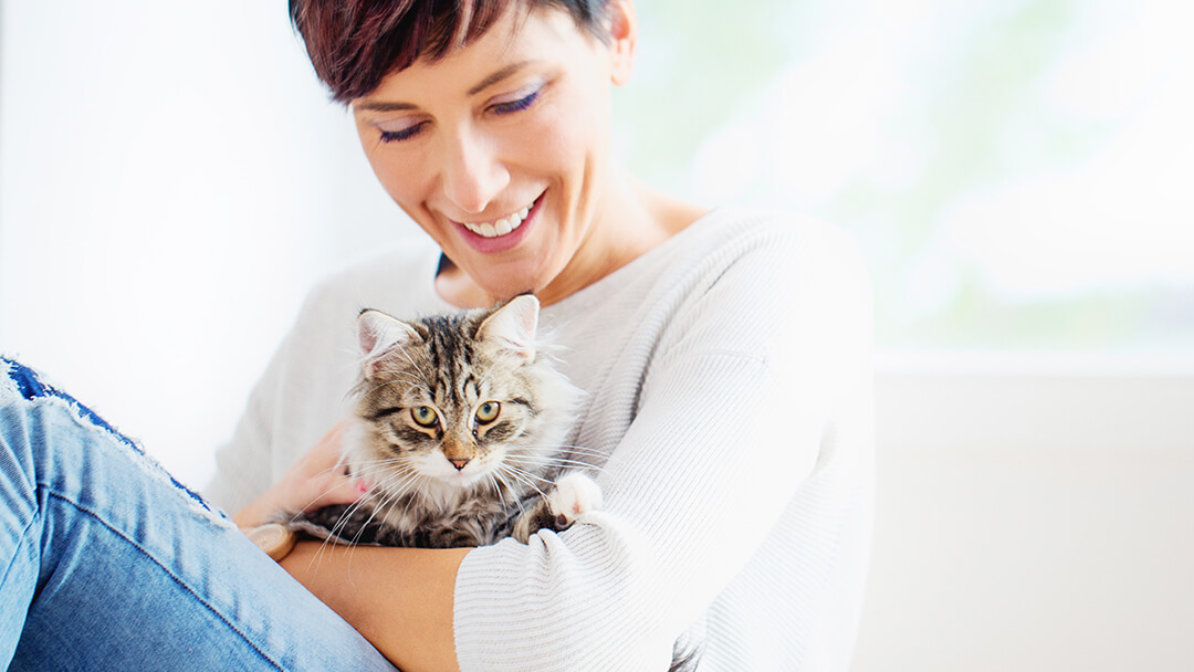 Woman holding cat at a cat sitting service