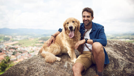 Man with golden retriever on the rock